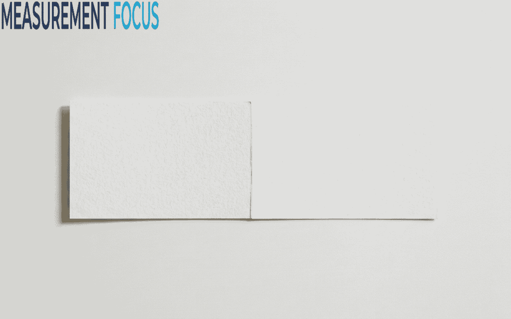 A top down photograph of a blank, open white card with a textured paper finish, centered against a light grey background with a side shadow.